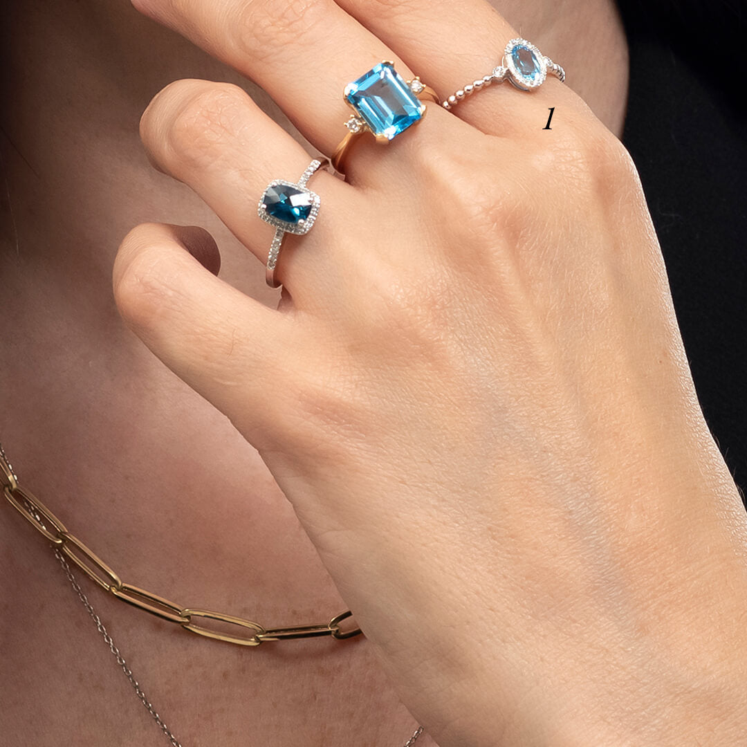 Anillo con Topacio Swiss Blue Corte Oval y Diamantes 0.10qts con Brazos Bolitas