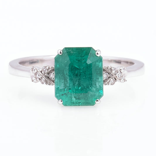 Anillo con esmeralda central y amarres laterales con diamantes